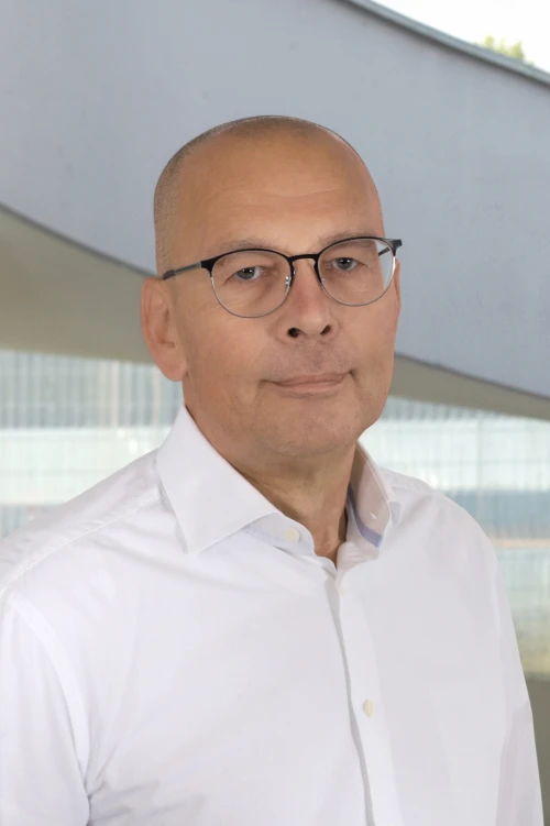 Portraitfoto von Jochen Sandfort, Mitarbeiter bei der TOPOS Versicherungskontor GmbH, vor einem neutralen Hintergrund.