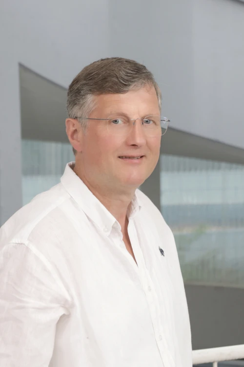 Portraitfoto von Norbert Hansen, Mitarbeiter bei der TOPOS Versicherungskontor GmbH, vor einem neutralen Hintergrund.