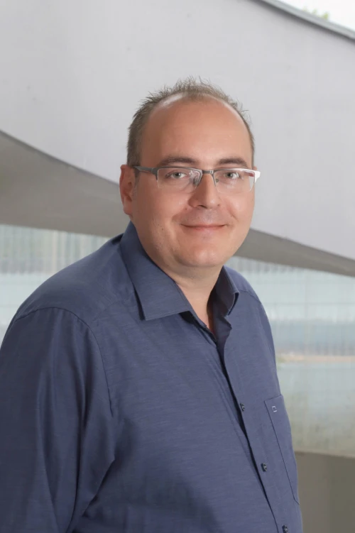 Portraitfoto von Patrick Delert, Mitarbeiter bei der TOPOS Versicherungskontor GmbH, vor einem neutralen Hintergrund.